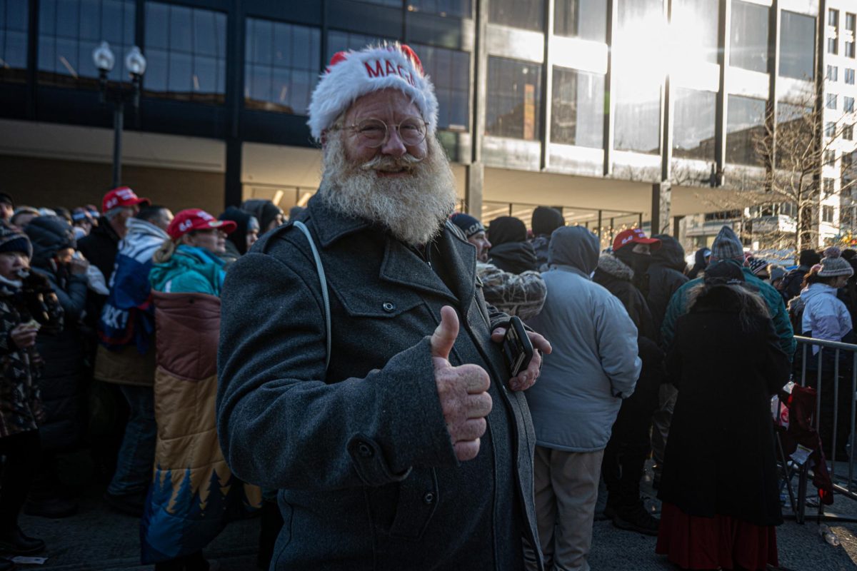 A Trump supporter wearing a MAGA Santa hat gives a thumbs-up as Trump is sworn-in for a second term. (Nick Peace for The Beacon)