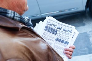 Doug Struck holds the latest issue of Discipline News on Boylston Street outside of Emerson College on Monday, Jan. 27, 2025. (Arthur Mansavage/ Beacon Staff)