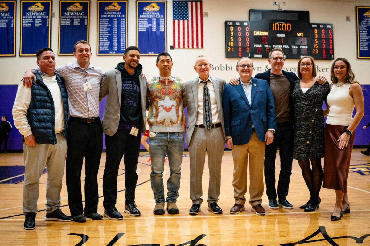 Former men's basketball head coach Hank Smith (center) poses with President Jay Bernhardt, several of his former players, and family members (Courtesy of Nate Gardner).