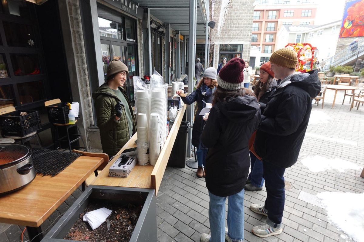 A vendor serves soup to customers. (McKenzie Cooper/ Beacon Staff)