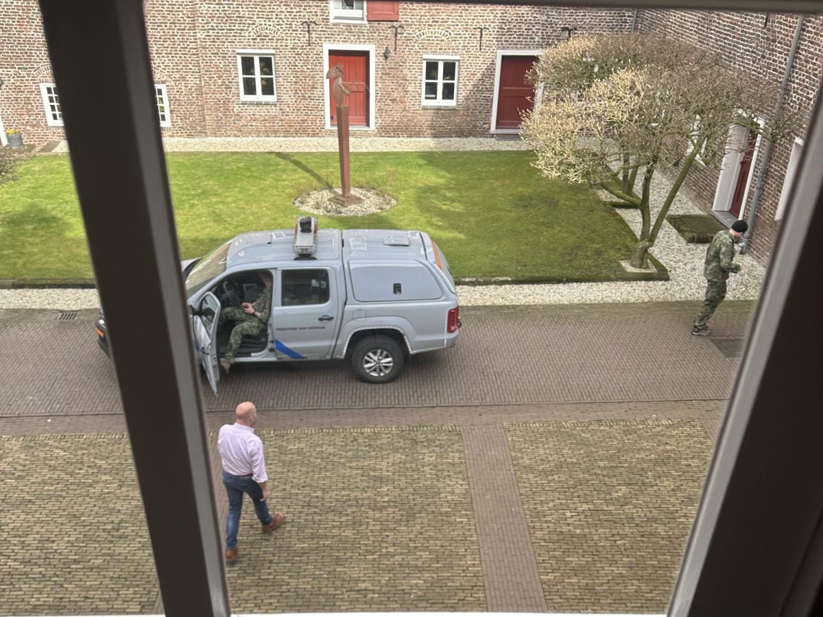 Emerson College European Center Assistant Director Rob Dückers approaches a member of De Explosieven Opruimingsdienst Defensie (EOD) inside the Kasteel Well courtyard after a WWII grenade was found on campus on Thursday, February 27, 2024 (Tallulah Schorvitz / Courtesy)