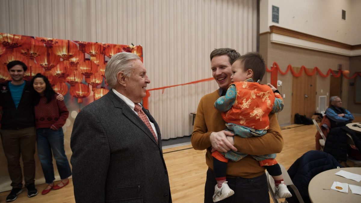 Senior Missionary Elder Butt and Assistant to the Bishop Stephen Patterson catch up over holiday fanfare in the Latter-day Saints' chapel gymnasium. (Bryan Liu/ For The Beacon)