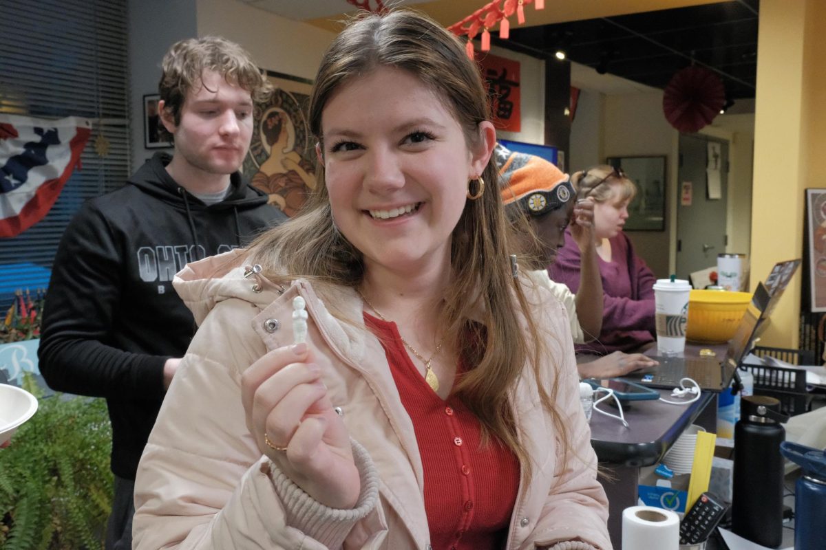 Evelyn Alumbreros, a senior musical theater student, finds a figurine of baby Jesus in the rosca de reyes. (Ryan Yau/ Beacon Staff)