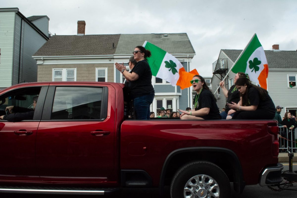 Parade participants waving flags from the back of a pickup truck in South Boston on Sunday, March, 16, 2025. (Ari Mei-Dan/ Beacon Staff)