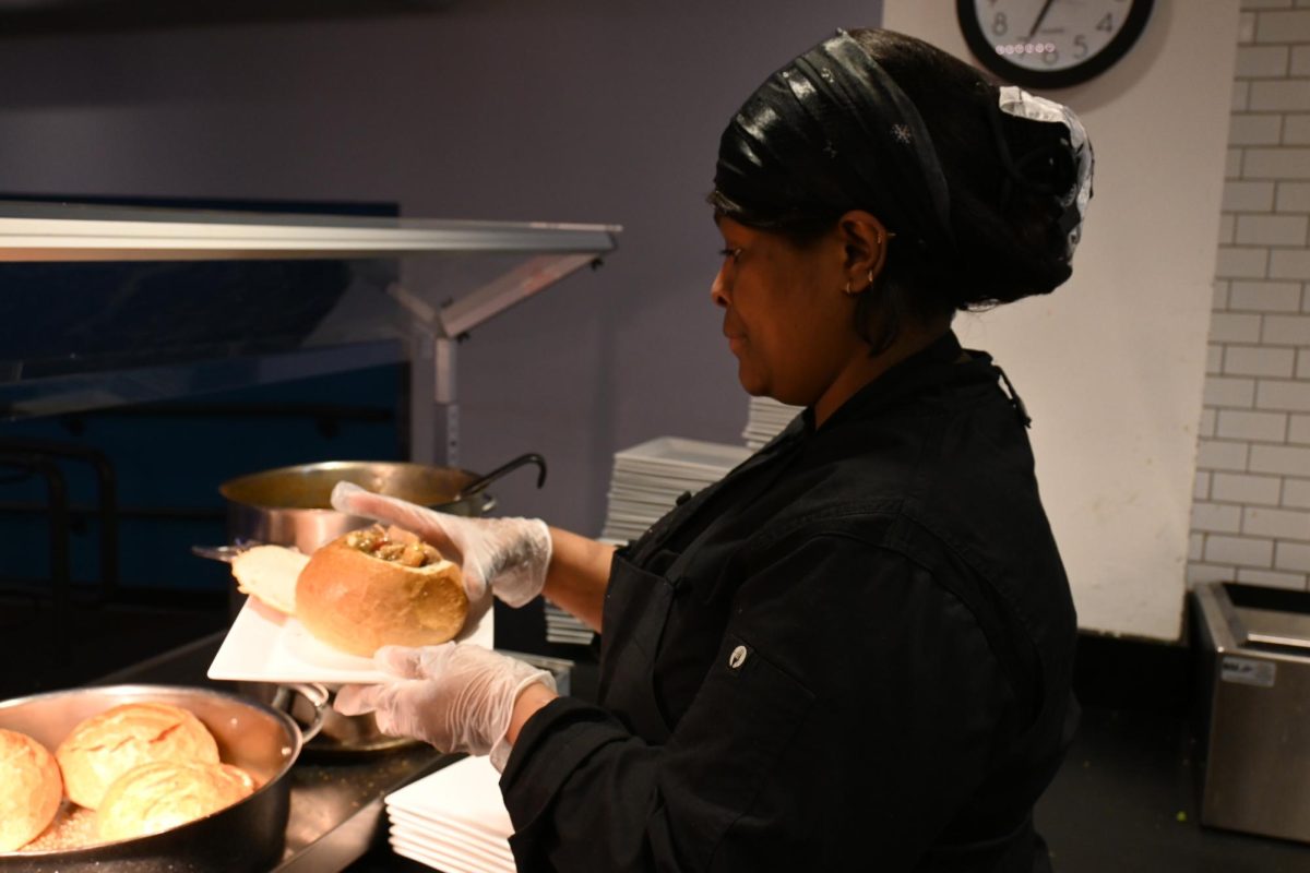 Wendy Montero serves up a bread bowl on the dining hall's Mardi Gras night. (Max Ardrey / Beacon Staff)