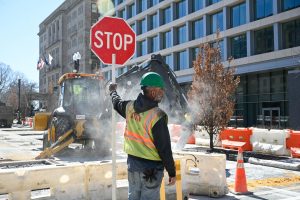 A construction worker halts traffic as a jackhammer breaks ground. (Norah Lesperance/ Beacon Correspondent)