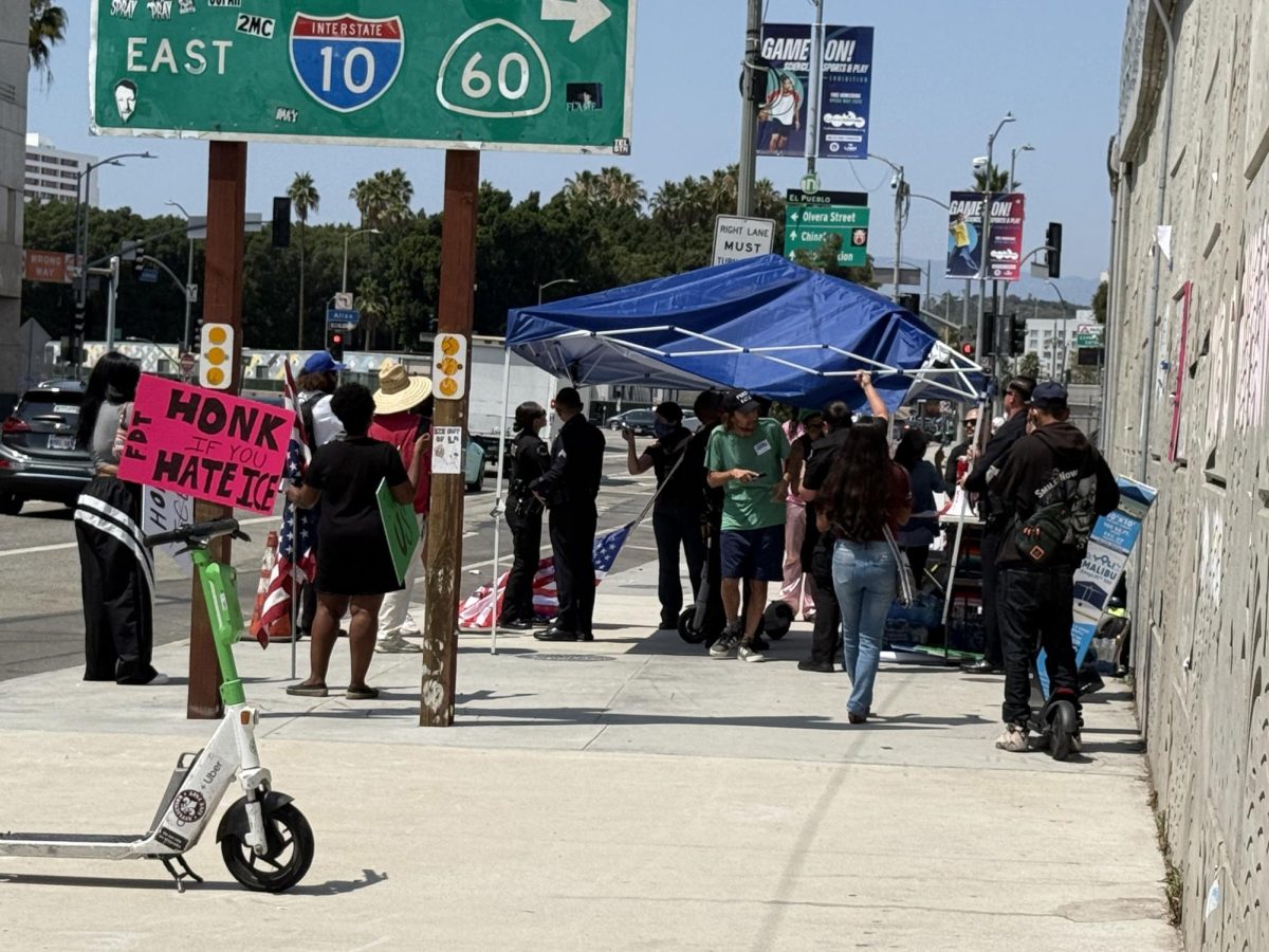 LAPD officers remove a canopy that belonged to an anti-ICE protester on July 18, 2025 (Jordan Pagkalinawan/ Beacon Staff).