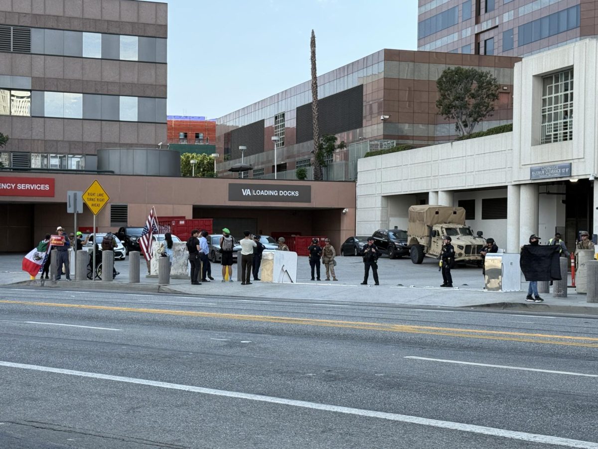 Protesters gather in front of Marines and LAPD officers protecting the Metropolitan Detention Center on July 19, 2025 (Jordan Pagkalinawan/ Beacon Staff)