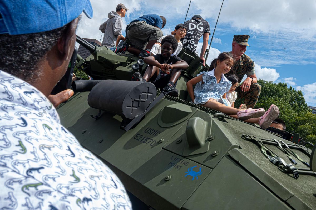 Kids sit atop a light armored vehicle on display in the Boston Common on Sunday, Aug 24, 2025. (Nick Peace / Beacon Staff)