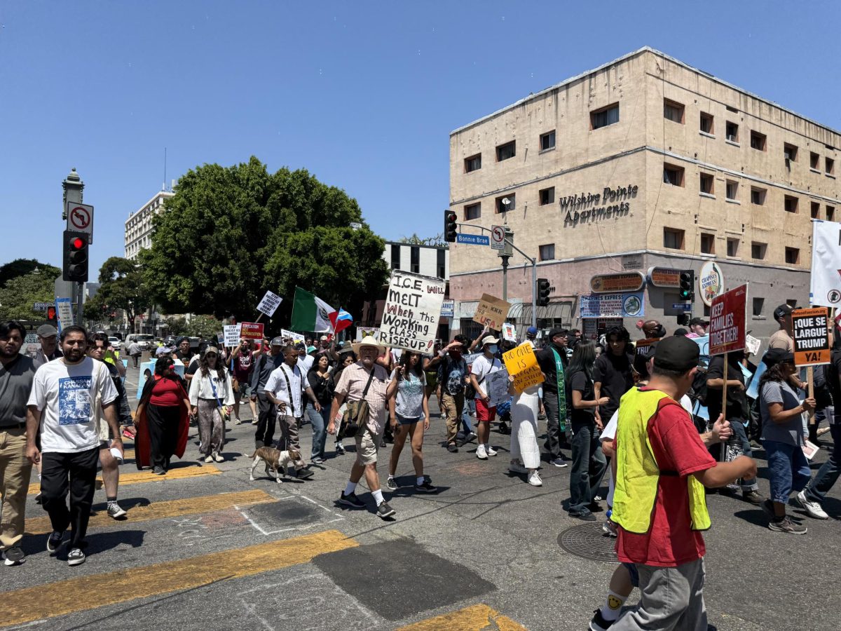 Protesters march along Wilshire Boulevard en route to a Home Depot where 16 immigrants were arrested (Jordan Pagkalinawan/ Beacon Staff).