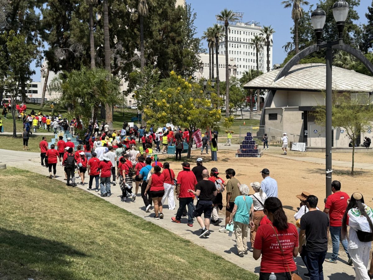 Demonstrators walk through MacArthur Park as part of a 24-hour community stoppage organized by the Summer of Resistance Coalition (Jordan Pagkalinawan/ Beacon Staff).