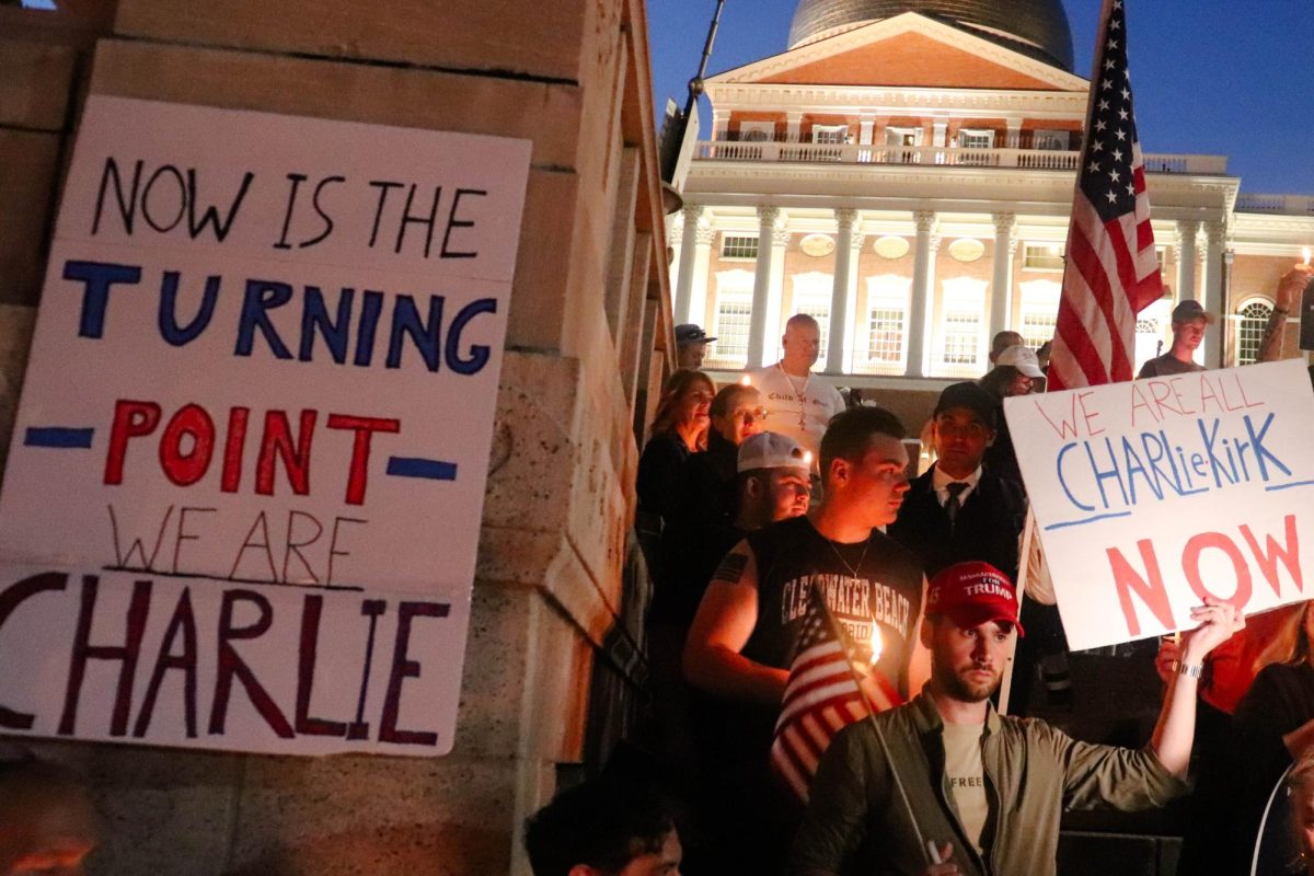 Attendees of a Charlie Kirk memorial vigil hold signs honoring the late activist in front of the Massachusetts State House on Thursday, Sept. 18, 2025. (Bryan Hecht / Beacon Staff)