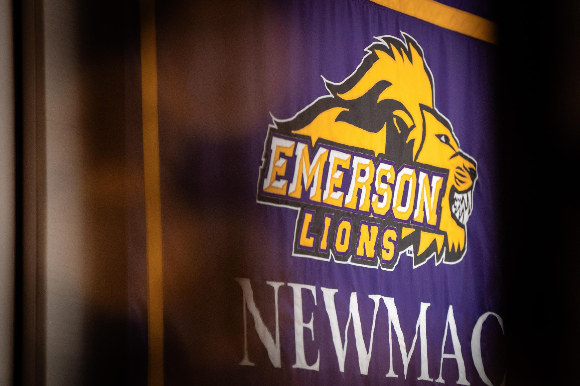 A banner displaying the Emerson Lions' NEWMAC achievements in the Bobbi Brown & Steven Plofker Gym (Courtesy of Nate Gardner).
