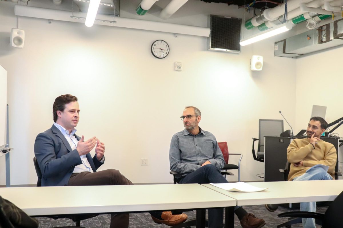 Evan Chapman (left) and Scott Clavenna (middle) talk about the change in sustainability policies following the transition from Biden to Trump's administration on Friday, Oct. 17, 2025. (Bryan Hecht / Beacon Staff)