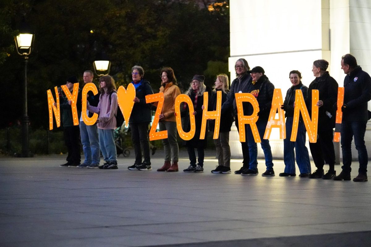A group of people hold up letters that spell out Zohran in Washington Square Park Tuesday evening. (Arthur Mansavage/ Beacon Staff)