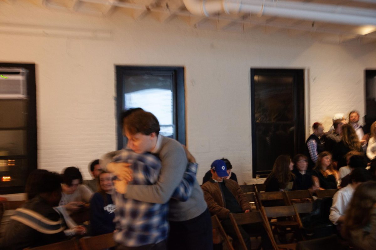 Supporters embrace at The Bench in Chinatown, where The Free Press is hosting an election night watch party. (Iselin Bratz/ Beacon Staff)