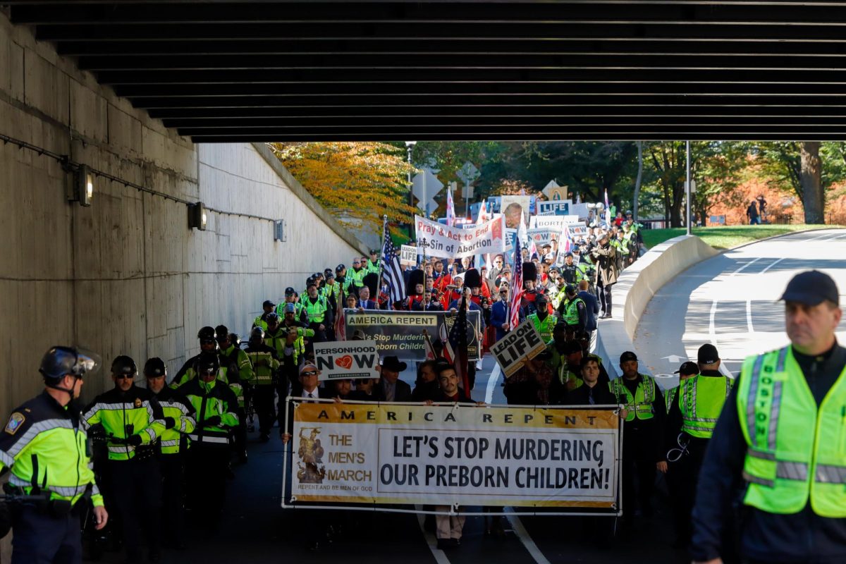 Dozens of police officers escort hundreds of anti-abortion marchers on Commonwealth Avenue under Massachusetts Avenue Saturday afternoon. (Arthur Mansavage/ Beacon Staff)