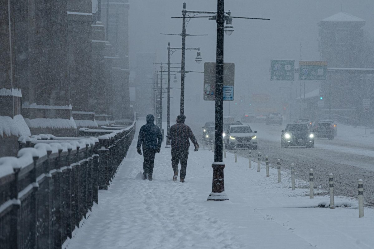 Two people walking down Charles River Dam Rd during the start of the snow storm on Sunday, Jan. 25, 2026 (Nick Peace/Beacon Staff)