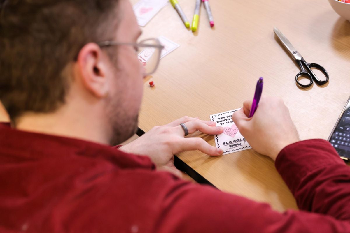 A staff member writes a message to the HR department in the Iwasaki Library during the Staff Union action on Wednesday, Feb. 18, 2026. (Arthur Mansavage/ Beacon Staff)