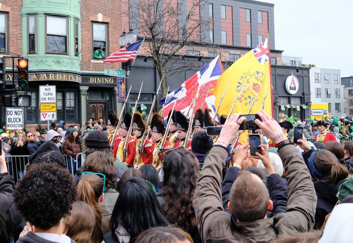A group of redcoat reenactors pass by a booing crowd at the end of the parade. (Jacob Goldberg/ Beacon Staff)